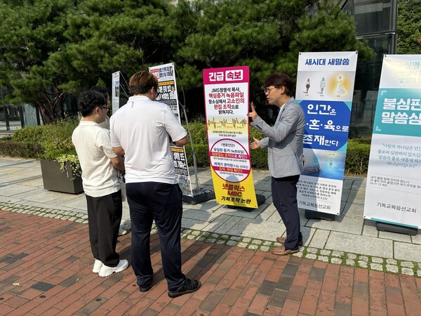 서울 대학로 마로니에 공원에서 버스킹 행사와 함께, 항소심 결심 공판을 앞둔 정명석 목사를 상대로  성피해를 입었다고 증거로 제출한 녹취록에서  조작된 정황이 확인되었다며 부산지역회 소속 문은상 장로가 지나가는 행인들에게 설명하고 있다.(사진제공=월간경제 황성익)